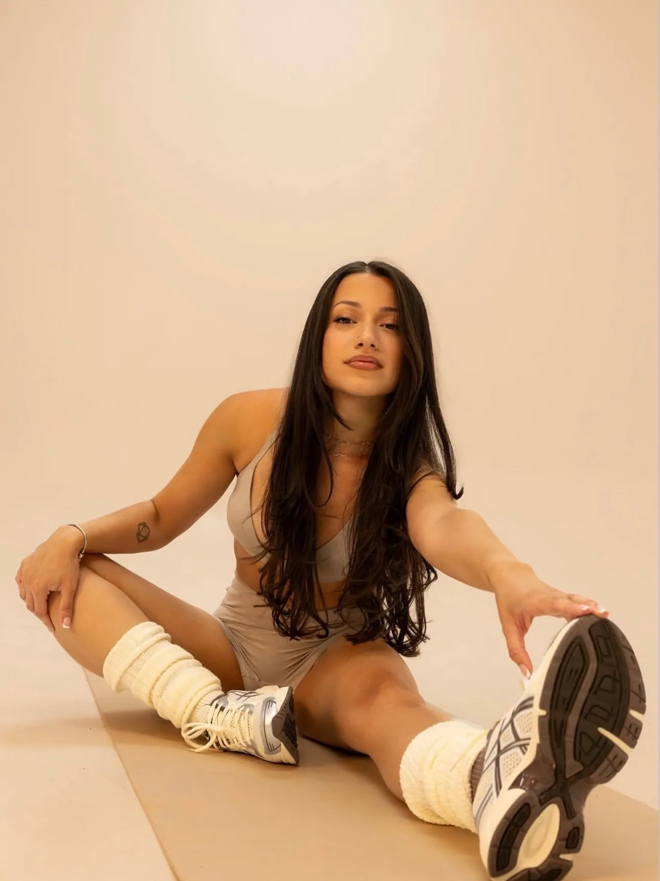 Denise in a wide seated stretch, reaching toward her foot