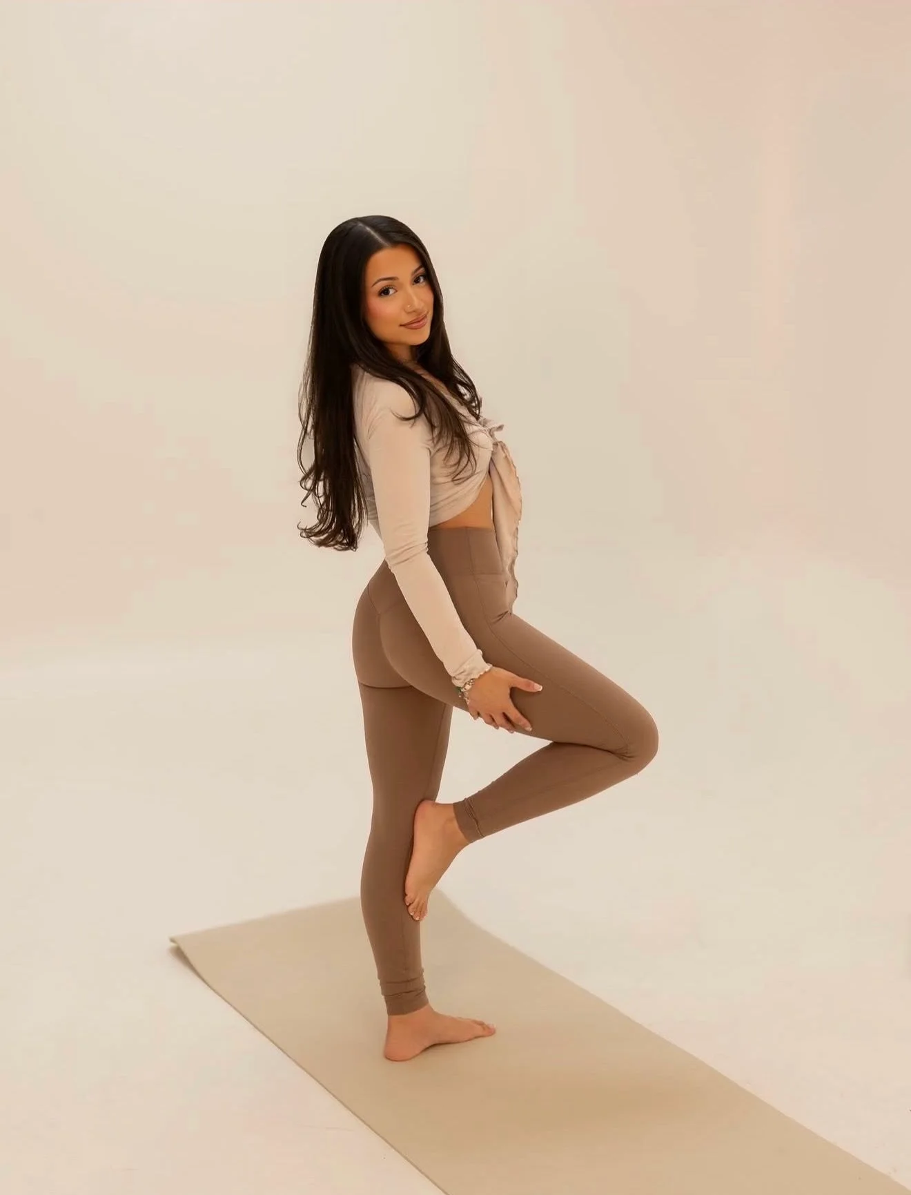 Denise balancing in a standing stretch on her mat